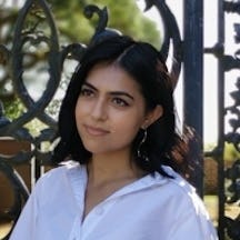 Head and shoulders photograph of a woman with dark hair wearing a white shirt