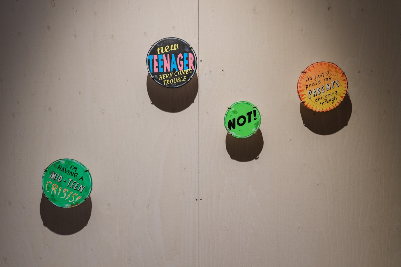 Colourful badges with slogans about adolescence.