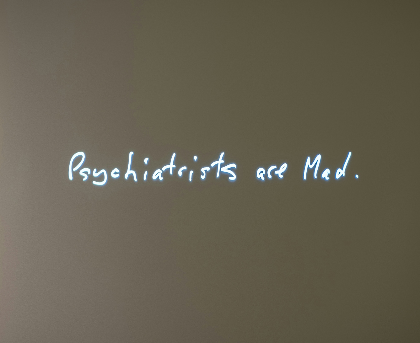 Image of a projection of a hand-painted sign called 'Psychiatrists are Mad' by Audrey Amiss.
