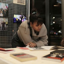 A photo of Vanesha leaning over a table, reading a book. 