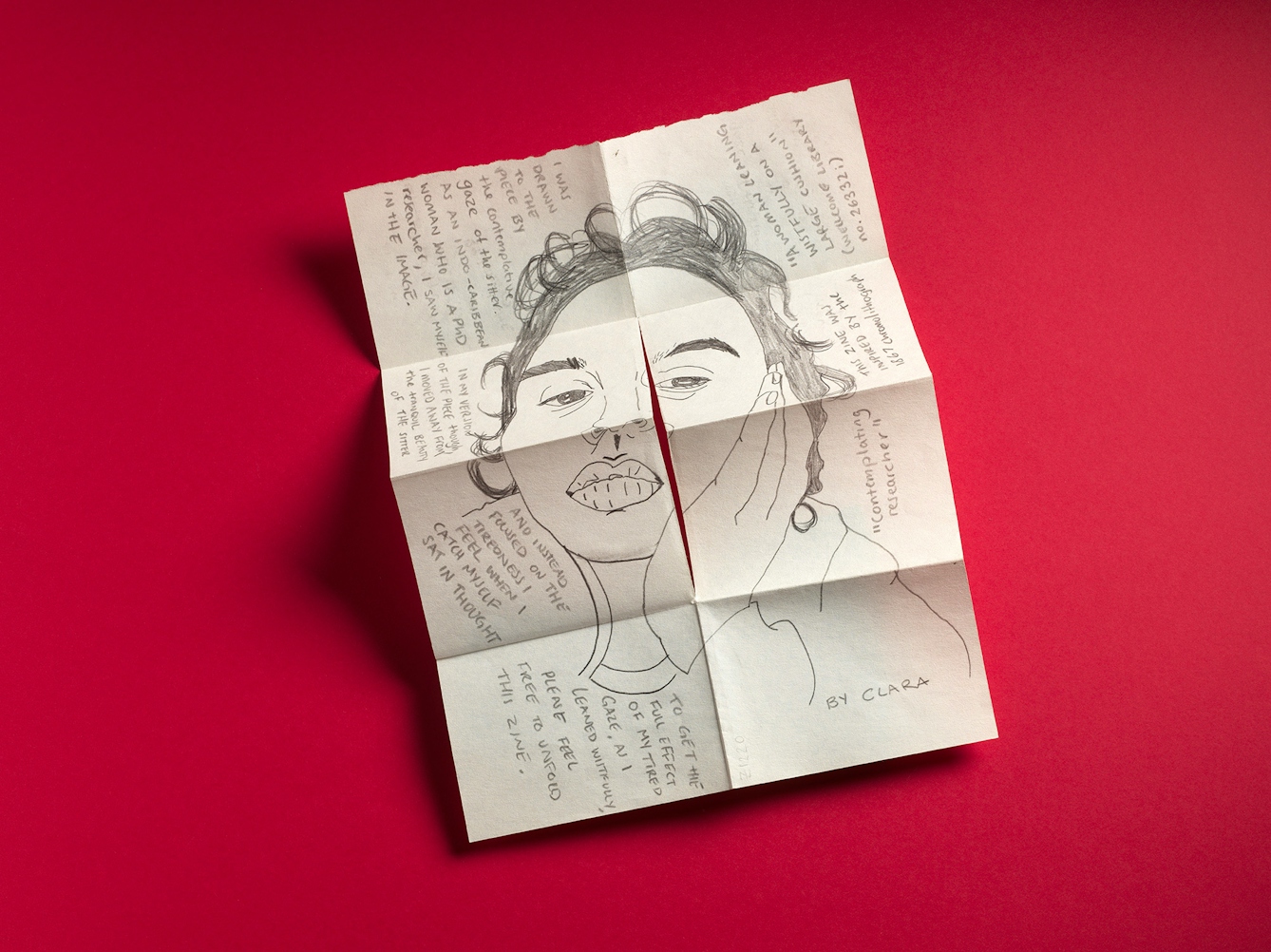 An open sheet of A4 paper with multiple folds and a cut to make it into an 8 page pocket zine. The page is dominated by a pencil illustration of a young woman's face and neck with her hand resting on one side of her face. Around the illustration, which flows into all eight pages is hand-written text. The zine is called 'Contemplating researcher' by Clara.